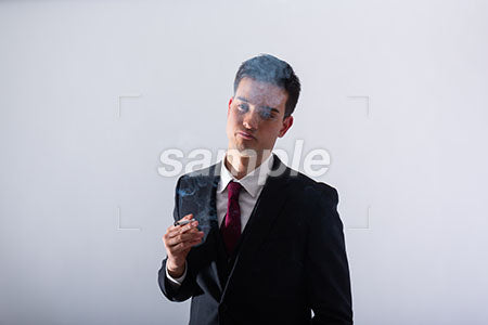 ビジネスマンの男性の悩む表情　タバコを持って考える a0011308PH