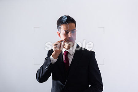 ビジネスマンの男性の瞑想の表情、煙草を持って目を閉じる a0011311PH