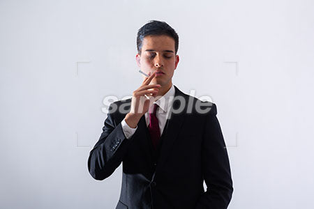 黒いスーツの男性がタバコを持って目を閉じる a0011313PH