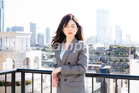 都会の屋上で目を閉じて正面を向く女性 a0020104PH
