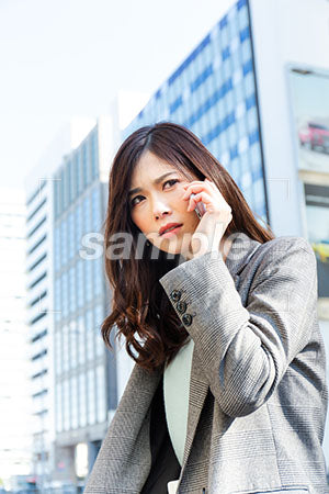 オフィス街で働く女性が怒りながら電話をする a0020191PH