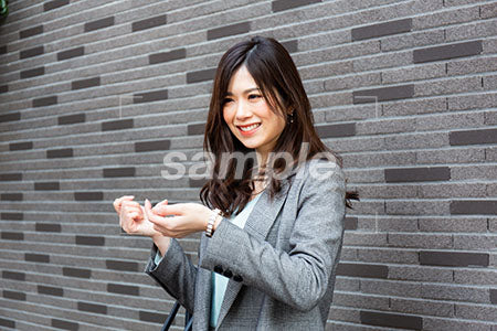 時計をきにしつつ女の人が左を向いて笑う a0020270PH