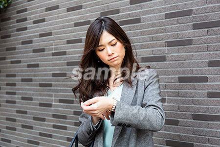 時間を気にしている女性が時計を見て考える a0020294PH