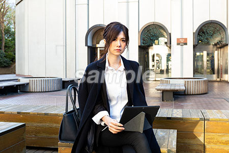 キャリアウーマンの女性の普通の表情　膝にパソコンを乗せる a0020491PH