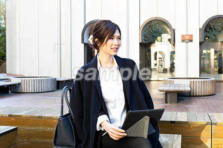 屋外で仕事をしている女性の右を見て微笑む a0020501PH