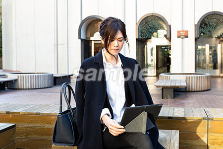 広場で仕事をしている女性のパソコンを見ている a0020511PH