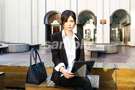屋外の広場で膝にパソコンを乗せる女性 a0020531PH