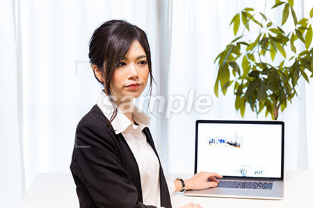 PCデスクの前でに座る女の人 a0020604PH