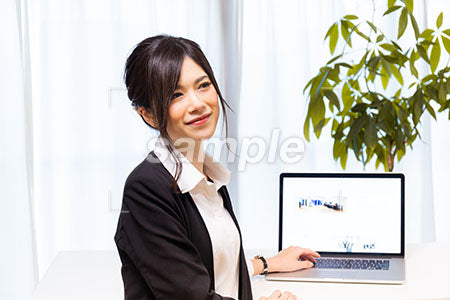 仕事をしながらパソコンの前で微笑む女性 a0020610PH