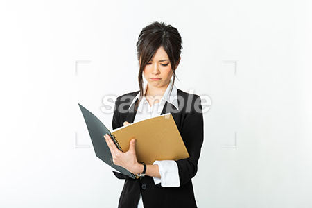 メモをとりながらノートを見て怒る女性 a0020719PH