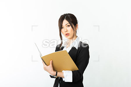 ノートをもってちょっと悩んでいる黒いスーツの女性 a0020726PH