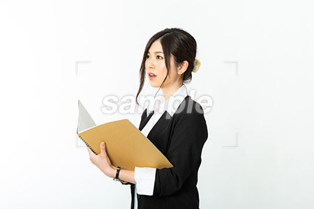 ノートになにかを書いている黒いスーツの女性 a0020727PH