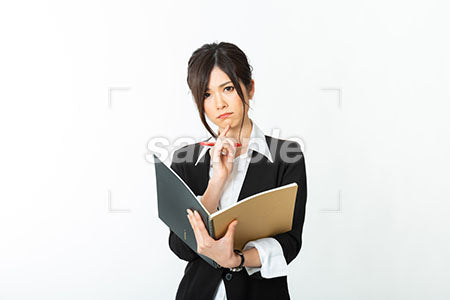 大きめのノートをもって考える女性 a0020735PH
