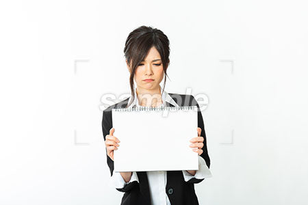 白いスケッチブックを見せていらっとしている女性 a0020771PH