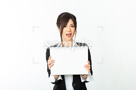 驚く表情の女性が白いスケッチブックを見せている a0020785PH