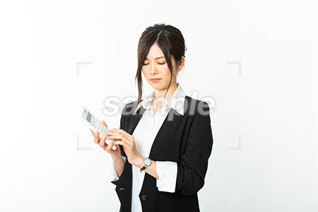 スーツの女性が電卓を持って瞑想している a0020839PH