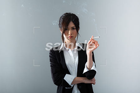 左手にタバコを持って正面を見るかっこいい女性 a0020847PH