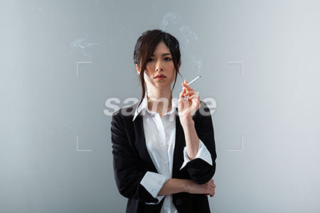 かっこいい女性の左手に煙草を持って正面を見る a0020848PH