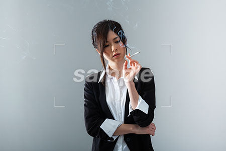 かっこいい女性が左手にタバコを持って下を見る a0020850PH