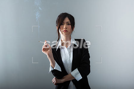 右手にタバコを持って正面を見るかっこいい女性の写 a0020853PH