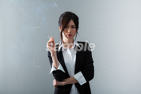 女性がけわしい顔で右手にタバコを持っている a0020866PH
