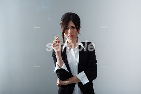女性が険しい表情で右手にタバコを持っている a0020867PH