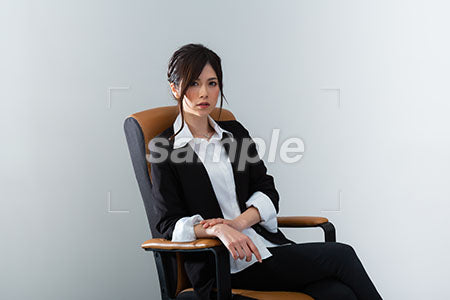 ビジネスチェアーに座って正面を見る女性社員 a0020952PH