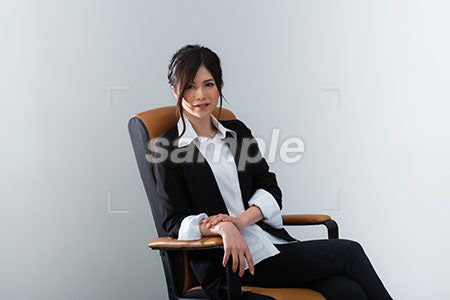 椅子にゆったりと腰掛けた女性が微笑む a0020957PH