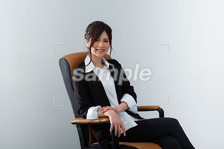 椅子に腰掛けた女性が笑って正面を見る a0020961PH