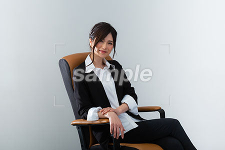 イスに腰掛けた女性がにこやかに正面を見る a0020962PH