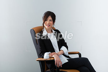 椅子に腰掛けた女性の笑顔の正面を見る a0020963PH