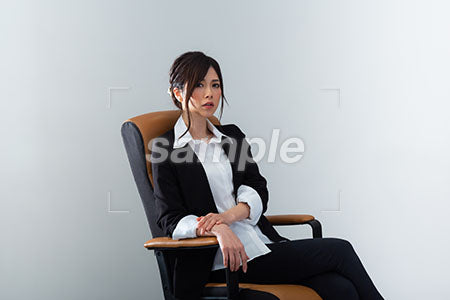 いすに座って驚くスーツの女性 a0020979PH