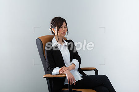 スーツの女性が座ってダルそうにしている a0020983PH