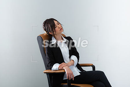 スーツの女性が座って目を閉じる a0020986PH