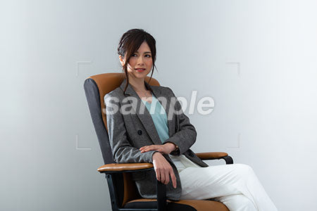 肘掛け椅子にすわり左上を見て微笑む女 a0020993PH