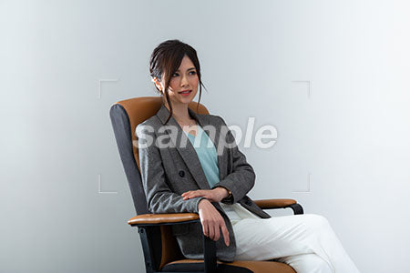 肘掛け椅子にすわり右上を見て微笑むOL a0020994PH
