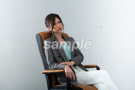 椅子に座って不機嫌な表情のOL a0021006PH