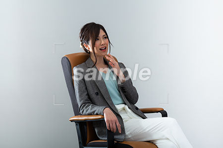 椅子に座って顎に手を添えて驚く、笑う女性 a0021019PH