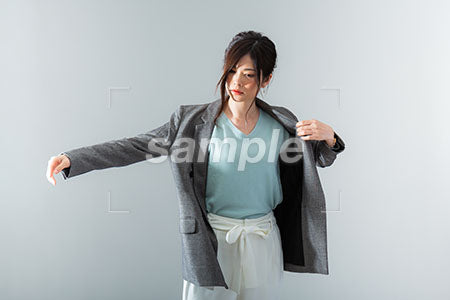 ジャケットの上着を着る仕草の女性 a0021037PH