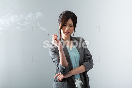 女性社員がタバコを持って笑う a0021047PH