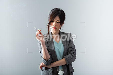 女性社員の悲しい表情、タバコを持つ a0021064PH