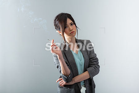グレー背景、タバコを持って考える女性 a0021074PH
