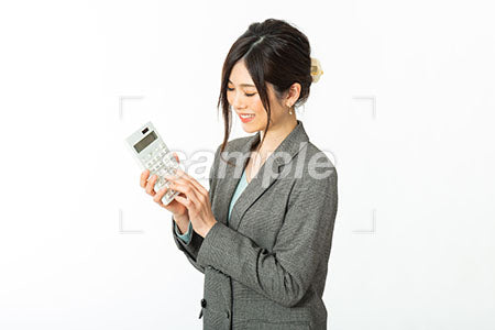 女性のにこやかなに笑う電卓を持っている a0021228PH