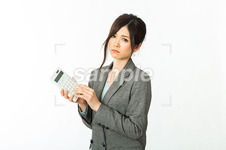 働く女性社員の悩む表情、電卓を持って考える a0021256PH