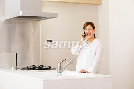 キッチンで電話する女性 a0030236PH