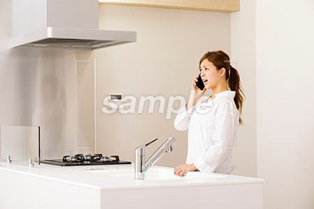 キッチンで怒りながらスマホで電話する女性 a0030250PH