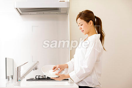 白いキッチンで皿を洗う美人の横顔 a0030269PH
