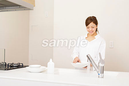 キッチンで皿を拭きながら女性 a0030278PH