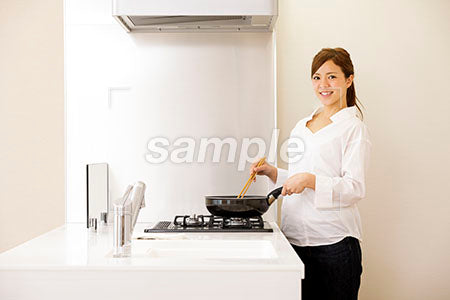 おうちで料理をしながら女性の笑う a0030294PH