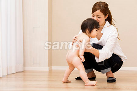 裸の赤ちゃんが立とうとしているのを支える母親 a0030325PH